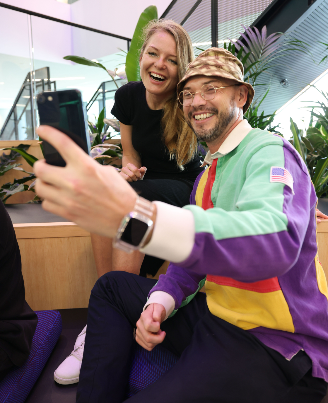 Two colleagues smiling while taking a selfie